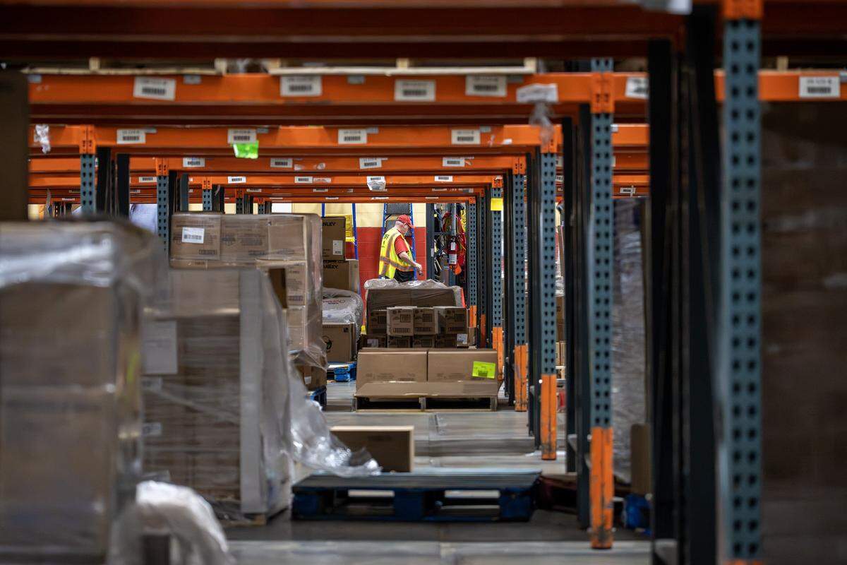 A staff member walks by partially empty shelves inside the Harvesters food bank warehouse on Tuesday, Oct. 28, 2025, in Kansas City. The organization is working to provide food to local pantries amid the ongoing government shutdown affecting SNAP benefits.