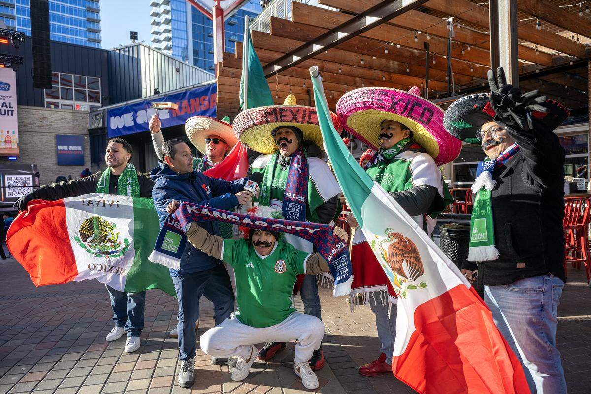 Mexico fans cheer as they are interviewed by a journalist during the FIFA World Cup draw watch party at the Power & Light District on Friday, Dec. 5, 2025, in Kansas City.