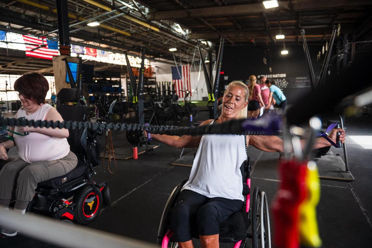 Lainie Rodgers pulls on elastic bands during a work out on at Brave Enough CrossFit in Kansas City. In 1994, Rodgers suffered a near fatal car accident that left her paralyzed below the waist.