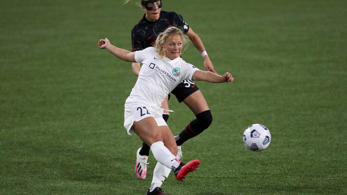 Kansas City’s Maddie Nolf kicks the ball to the outside while under pressure from Portland’s Celeste Boureille during an NWSL Challenge Cup soccer match on Friday, April 9, 2021, in Portland.