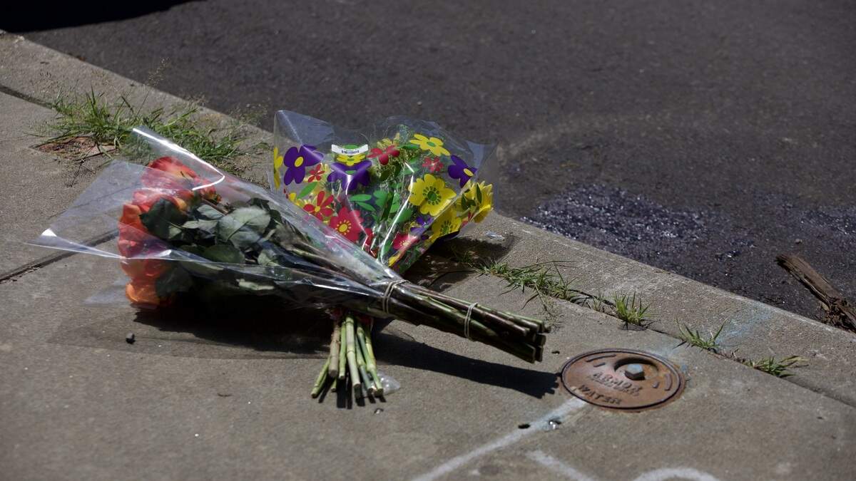 Flowers are laid on the sidewalk at 19th and Vine streets on Saturday, June 20. Police said several people were injured and one man was killed in a shooting in the area the night before.