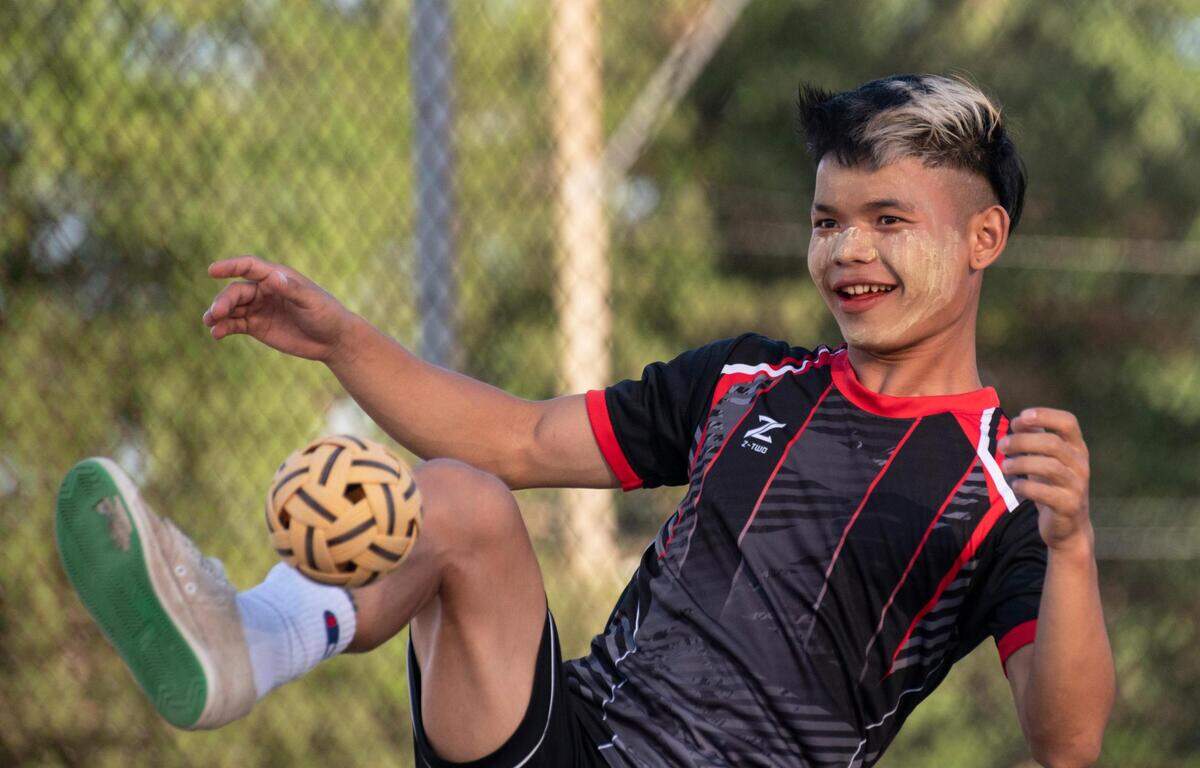 Lwi Say serves as he and friends play chinlone late in the afternoon at Sheffield Park in Kansas City on June 13, 2022.
