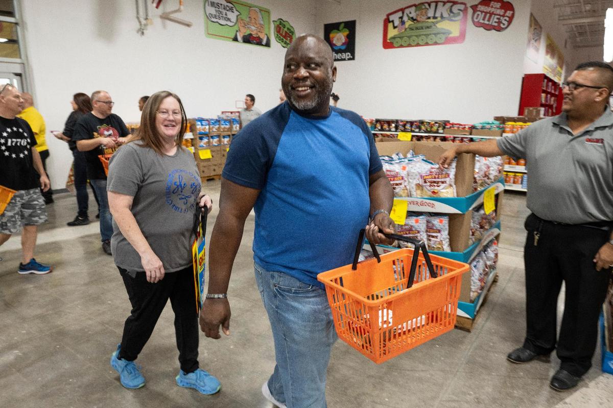 Chris, center, and Jodi Hudson of Overland Park were the first customers at Wednesday’s grand opening of the new Ollie’s.