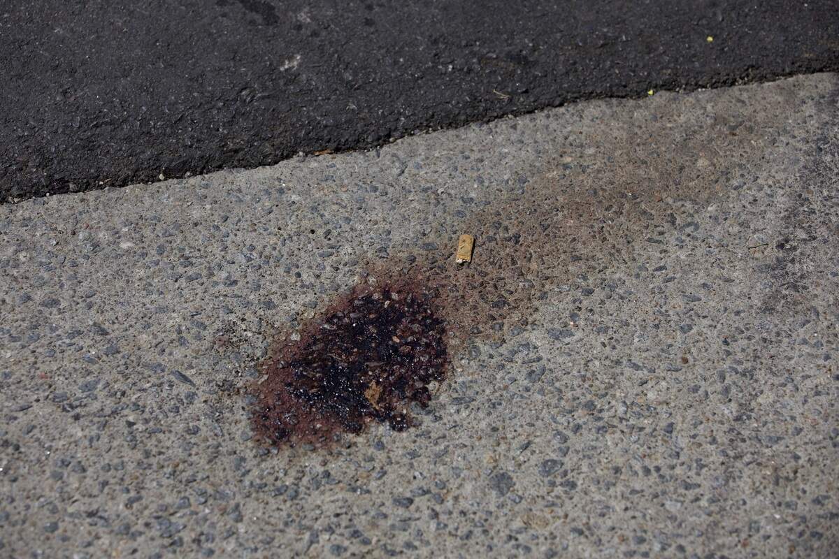 A blood stain remains on the street at 19th and Vine streets on Saturday, June 20. Police said several people were injured and one man was killed in a shooting in the area the night before.