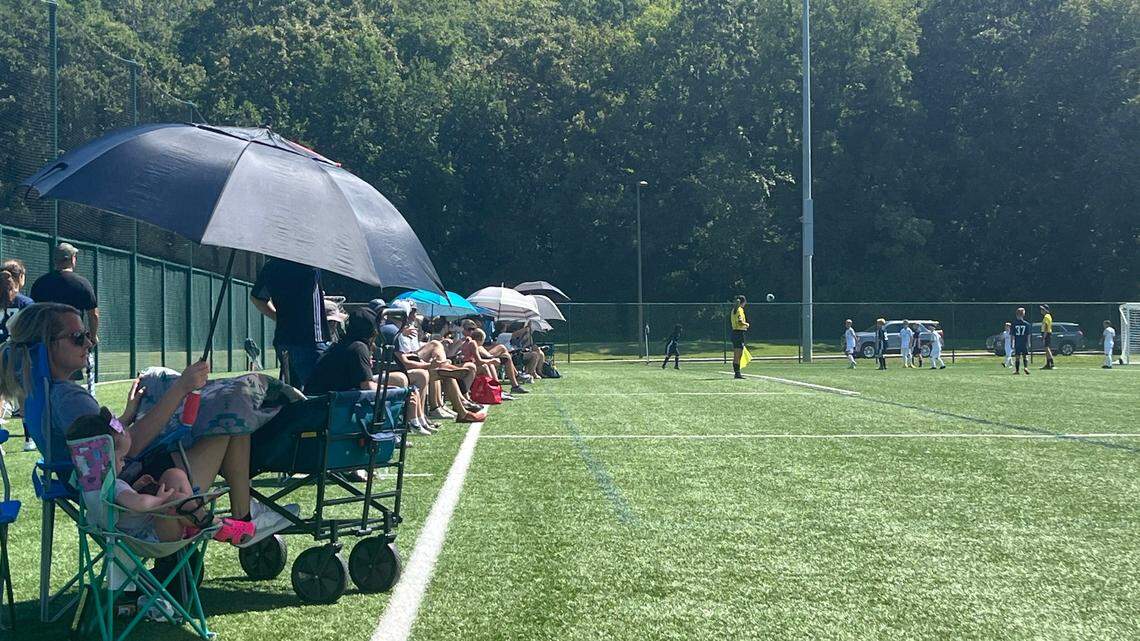 Parents lined up under umbrellas to watch their kids play soccer Sunday at Compass Minerals Sporting Fields amid an excessive heat warning in the metro area.