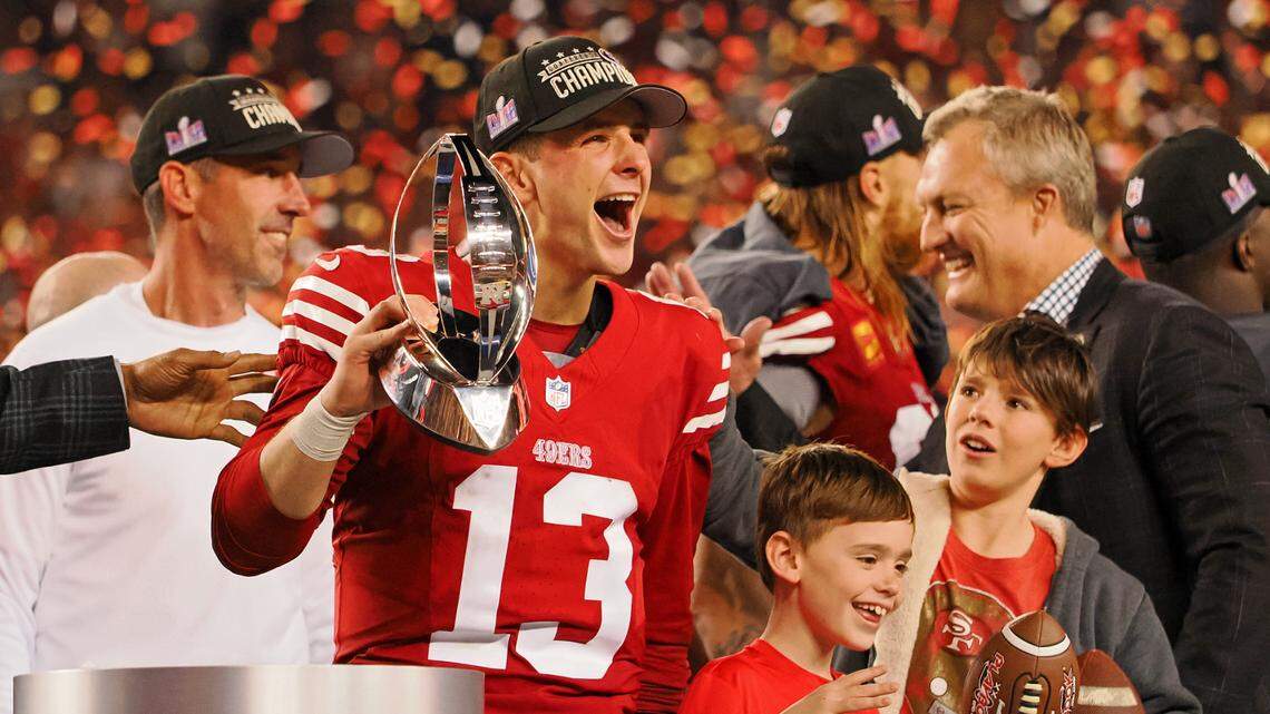 San Francisco 49ers quarterback Brock Purdy (13) holds the George Halas Trophy while after winning the NFC Championship football game against the Detroit Lions at Levi’s Stadium.