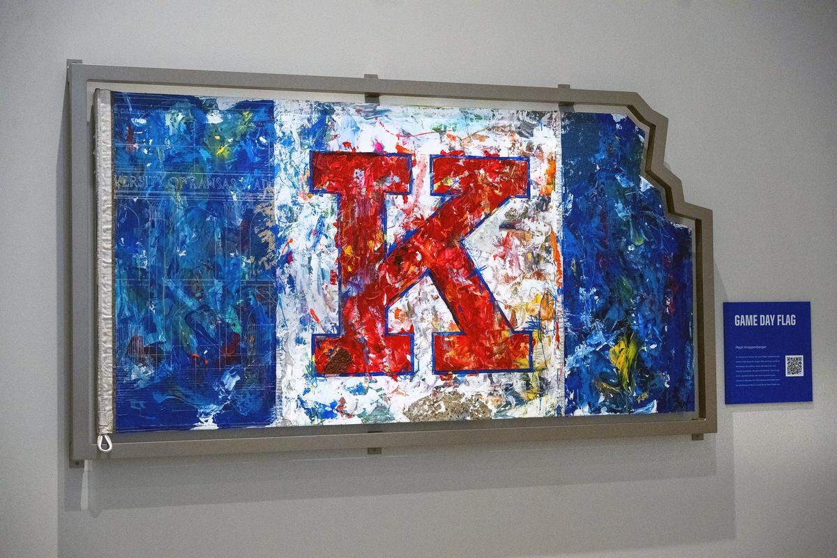 Artist Megh Knappenberger of Kansas City created the "Game Day Flag" artwork, which is a tribute to the flag that has flown over Fraser Hall for more than 50 years. The piece, prominently displayed inside the Anderson Family Football Complex, incorporates pieces of the old stadium and is a "love letter to that tradition."