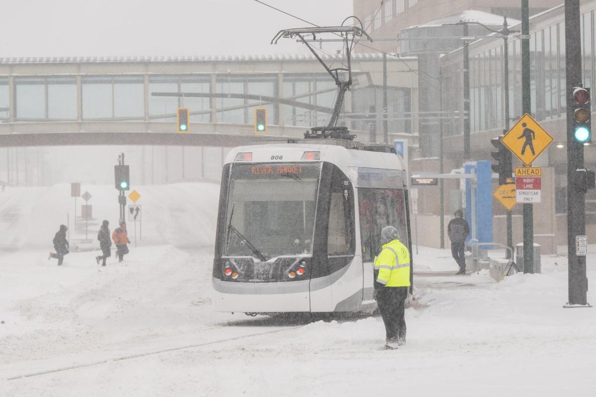 Pedestrians run to catch the KC Streetcar near Crown Center in Kansas City on Sunday, Jan. 5, 2025.