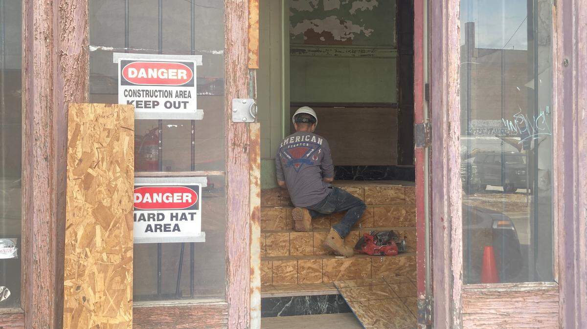 A carpenter with Rau Construction sets plywood inside the entrance of the Moline Plow Company buildling, 1015 Mulberry St., where the seven-story building is now being renovated into a 121-unit luxury loft apartment building.