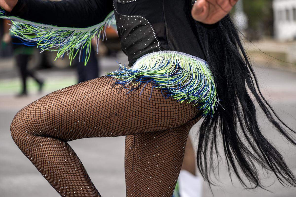 A dancer's costume ruffles sway as they perform along Broadway Boulevard during the St. Patrick's Day parade on Tuesday, March 17, 2026, in Kansas City.
