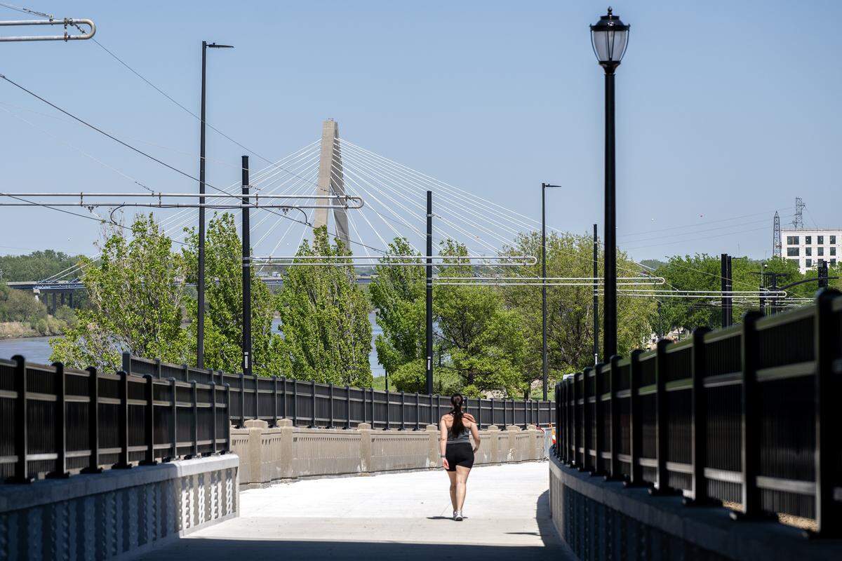 A person walks along the Grand Boulevard Pedestrian/Bike Bridge on Monday, April 20, 2026, in Kansas City.