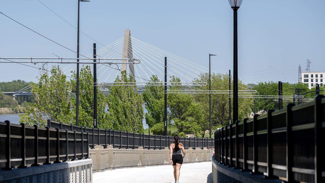 A person walks along the Grand Boulevard Pedestrian/Bike Bridge on Monday, April 20, 2026, in Kansas City.
