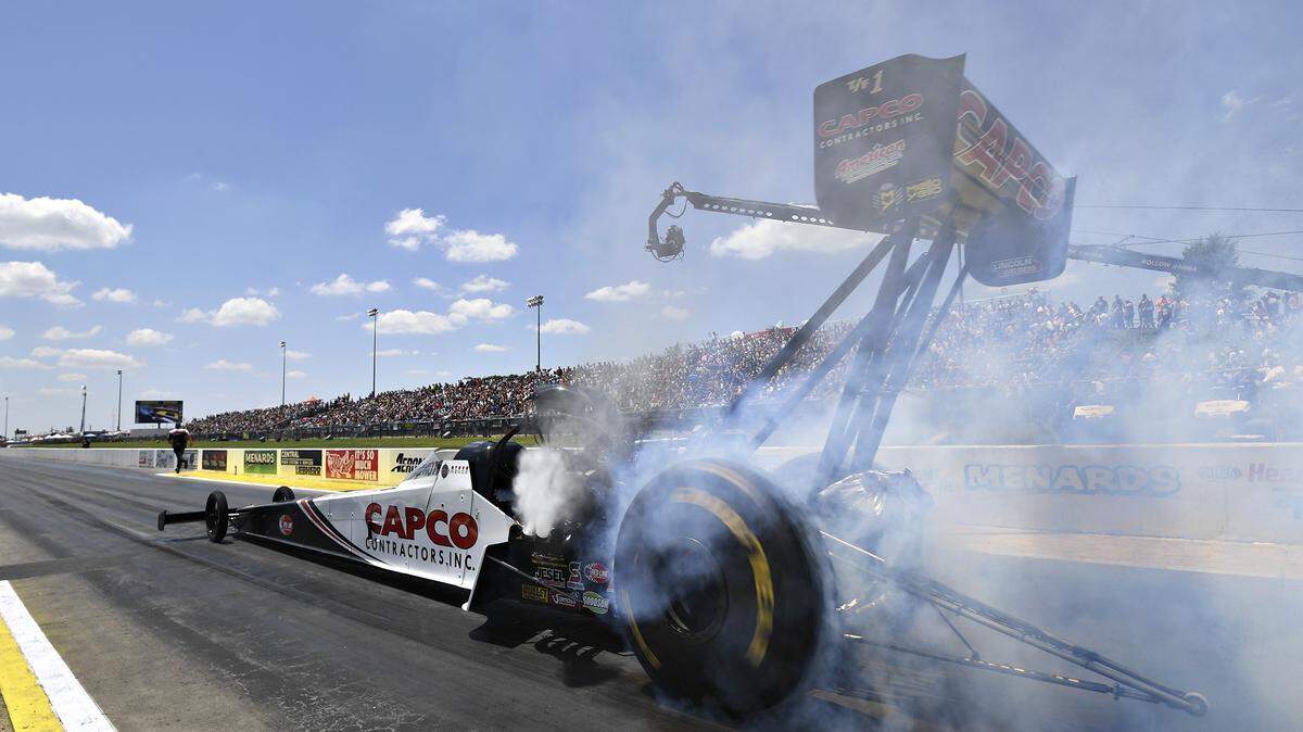 In this photo provided by the NHRA, Steve Torrence does a burnout in Top Fuel qualifying at the Menards NHRA Heartland Nationals drag races Saturday, June 8, 2019, in Topeka, Kan. (Marc Gewertz/NHRA via AP)