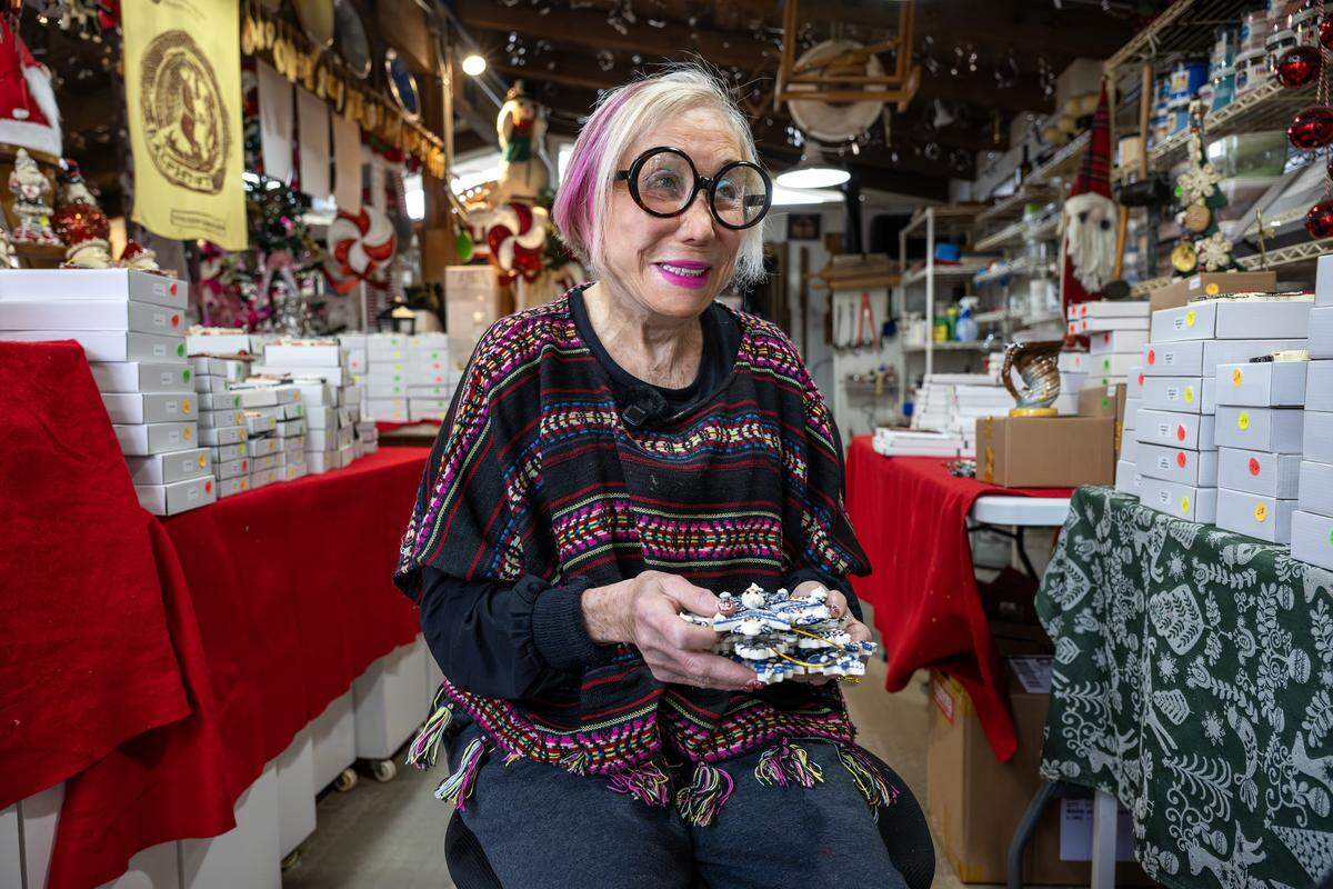 Ceramic artist Irma Starr sits inside her home studio holding a selection of her handmade ornaments on Thursday, Dec. 11, 2025, in Kansas City.