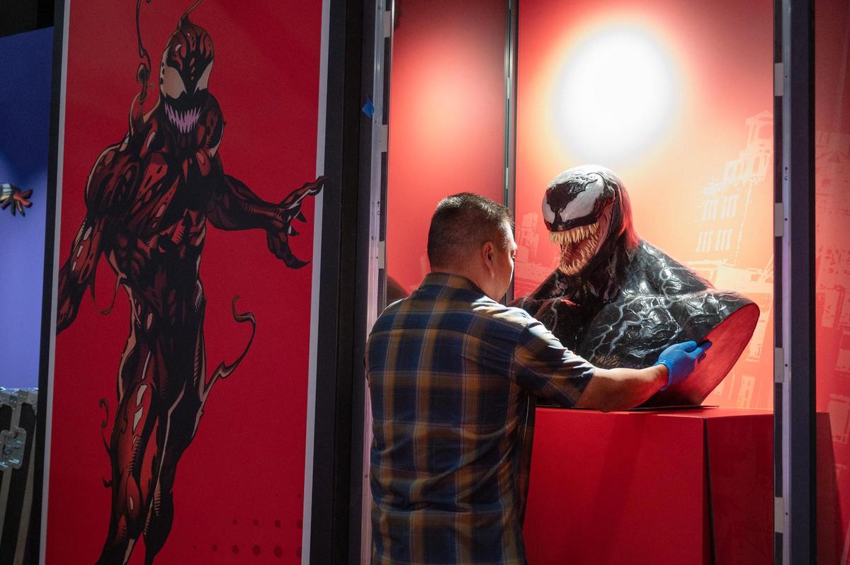Gilbert Emralino, senior archivist at Sony Pictures Entertainment, puts a life-size bust of the character, Venom, on display during the “Spider-Man: Beyond Amazing” exhibit set up Monday at Union Station.