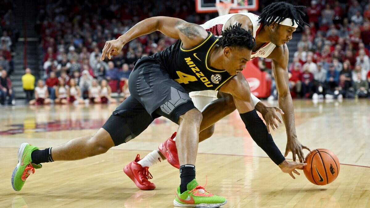 Missouri guard DeAndre Gholston (4) and Arkansas guard Ricky Council IV (1) go after the ball during the first half on Wednesday, Jan. 4, 2023, in Fayetteville, Ark.
