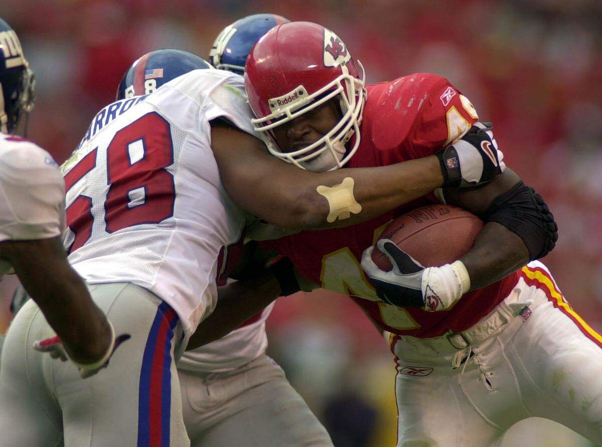 Chiefs fullback Tony Richardson, right, is tackled by the New York Giants’ Mike Barrow on Sept. 23, 2001 at Arrowhead Stadium. The Giants won the game 13-3.