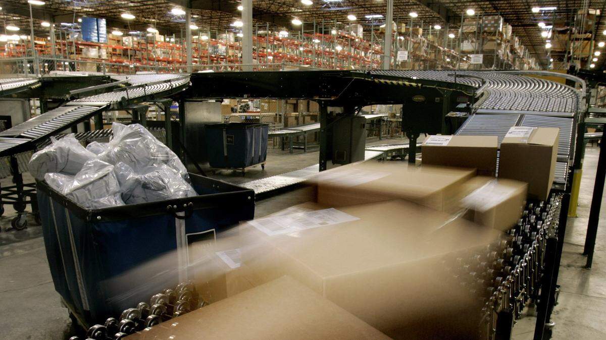 Boxes filled with merchandise travel down a conveyor system to waiting trucks for shipment at the Overstock.com warehouse in Salt Lake City.  A similar distribution facility will be up and running in Kansas City, Kan.