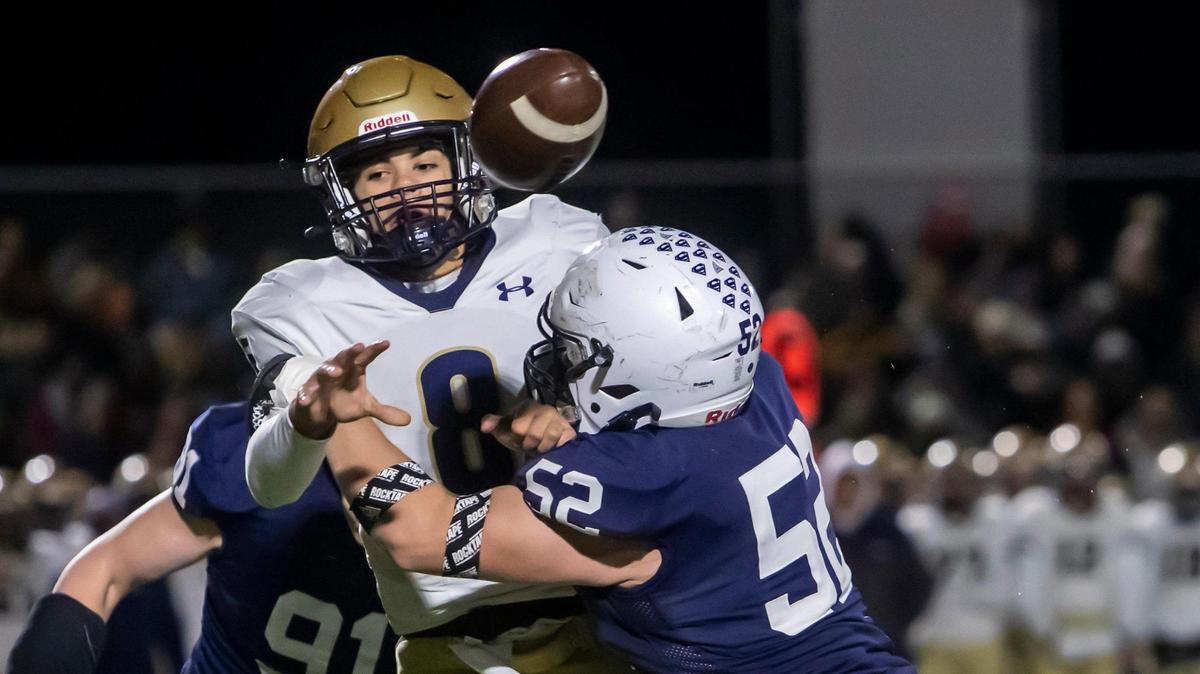 Mill Valley defensive lineman Grant Rutkowski (52) tackles St. Thomas Aquinas quarterback Maxxwell Ford (8) while attempting a pass during the sub-state championship game between Mill Valley and St. Thomas Aquinas on Friday November 19, 2021 in Shawnee, KS.