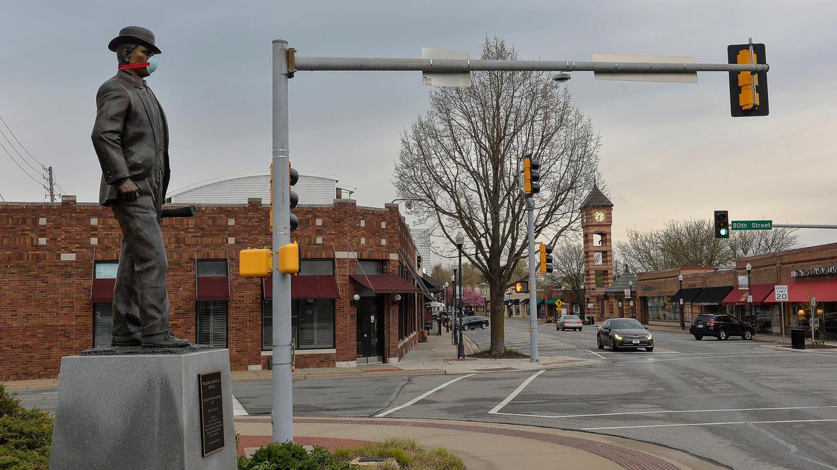 Adorned by a mask, the statue of William Strang Jr., the founder of Overland Park, looks out over the historic downtown of the city. Most of the businesses along Santa Fe Drive have been closed the past few weeks.