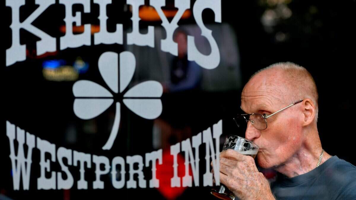 Roy Wiltrout, a fixture in the front window of Kelly’s Westport Inn most afternoons, sips on a cold pint while taking in the scenery passing by on Westport Road.