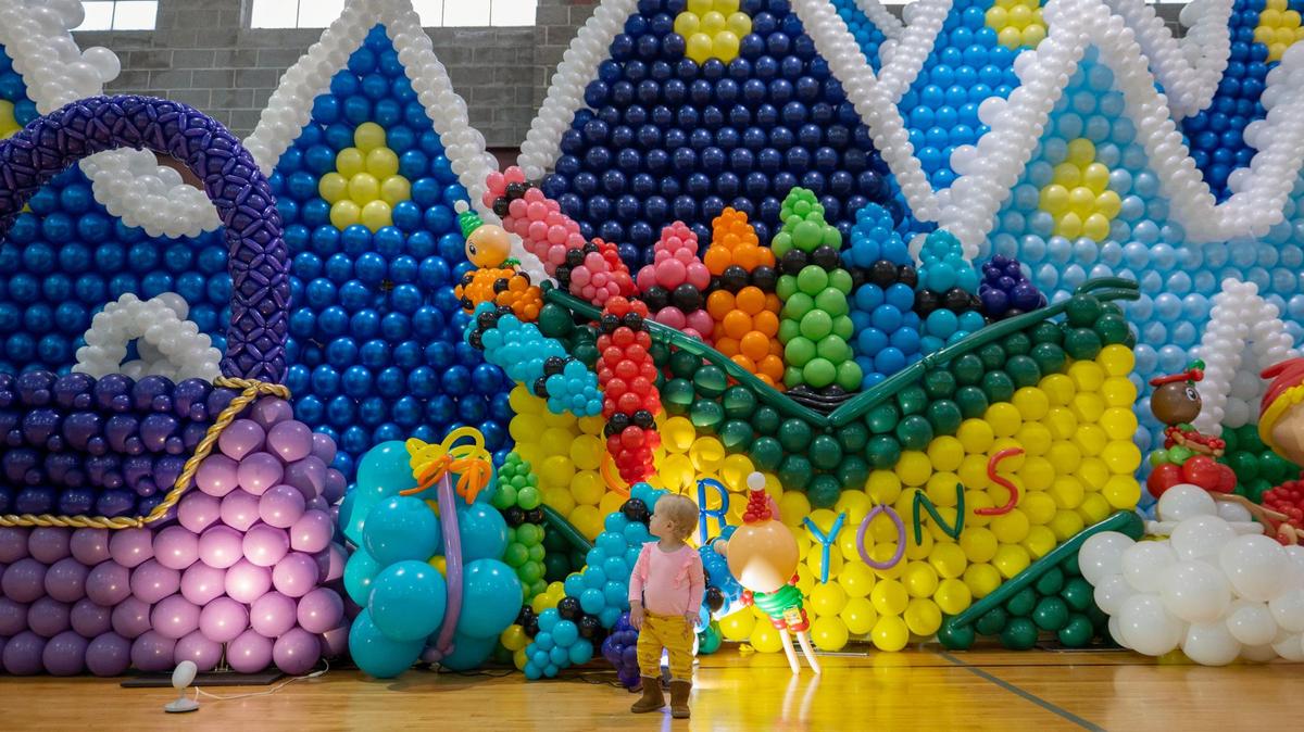 One-year-old Annabelle Phillips examines the installations in the Big Balloon Build at Gregg/Klice Community Center on Friday, Dec. 2, 2022, in Kansas City. The event is an international festival gathering balloon artists from all over the world to create a holiday toy town.