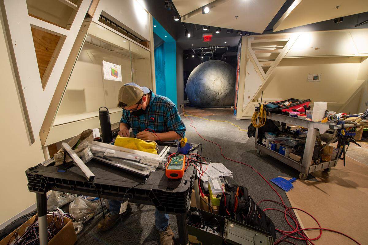 Josh Peterson works on the lighting of a globe inside the Truman Library, which will be filled with multimedia and interactive exhibits.