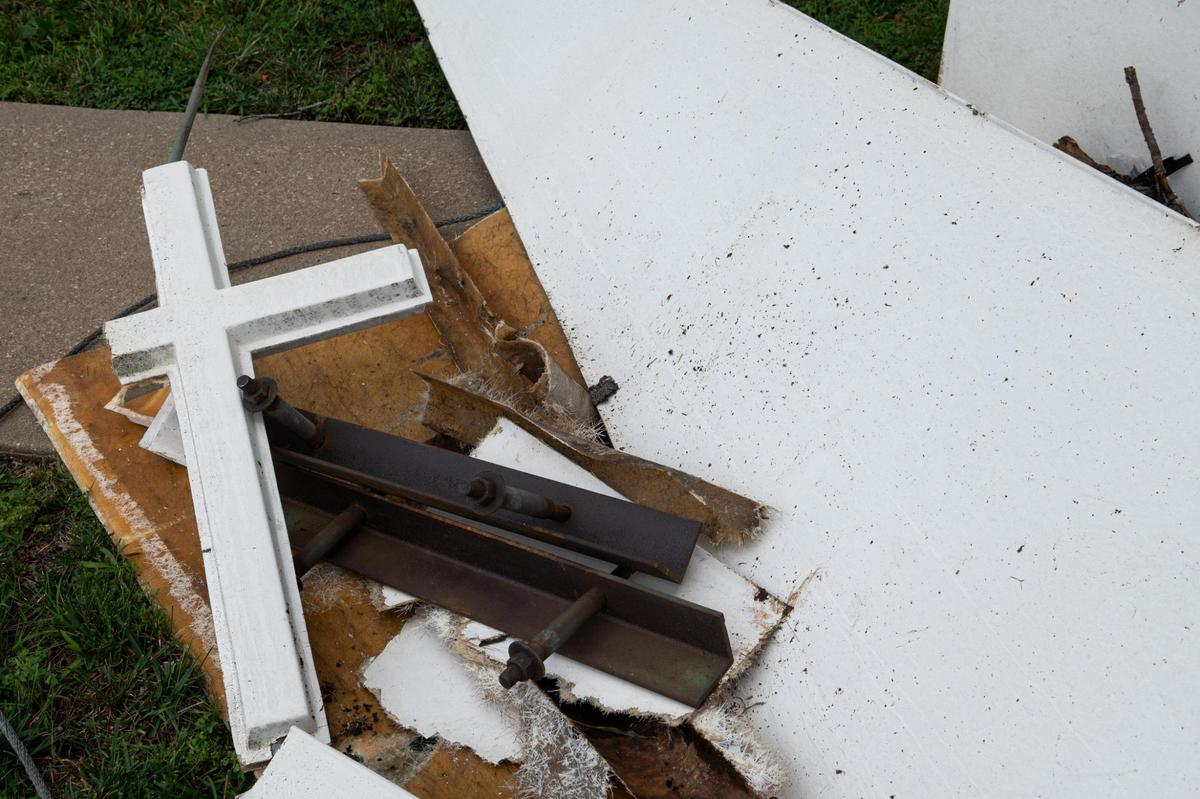 A broken cross and debris from the Maywood Community Church’s steeple sits on the ground outside of the church on Monday, July 31, 2023, in Kansas City, Kansas. The steeple blew off the church during a Sunday night storm.