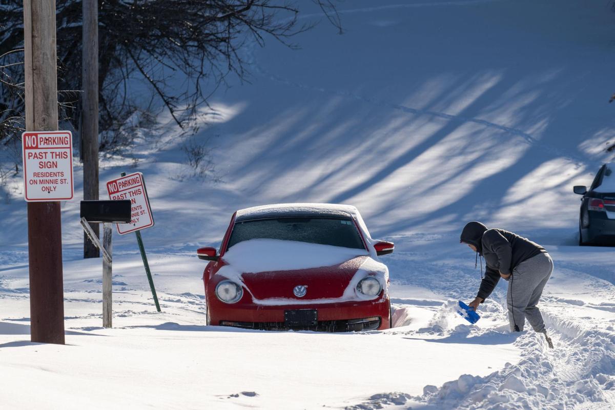 A man works to dig out his car from the snow along Southwest Boulevard in Kansas City on Monday, Jan. 6, 2025. The Kansas City metro area received record snowfall on Sunday.