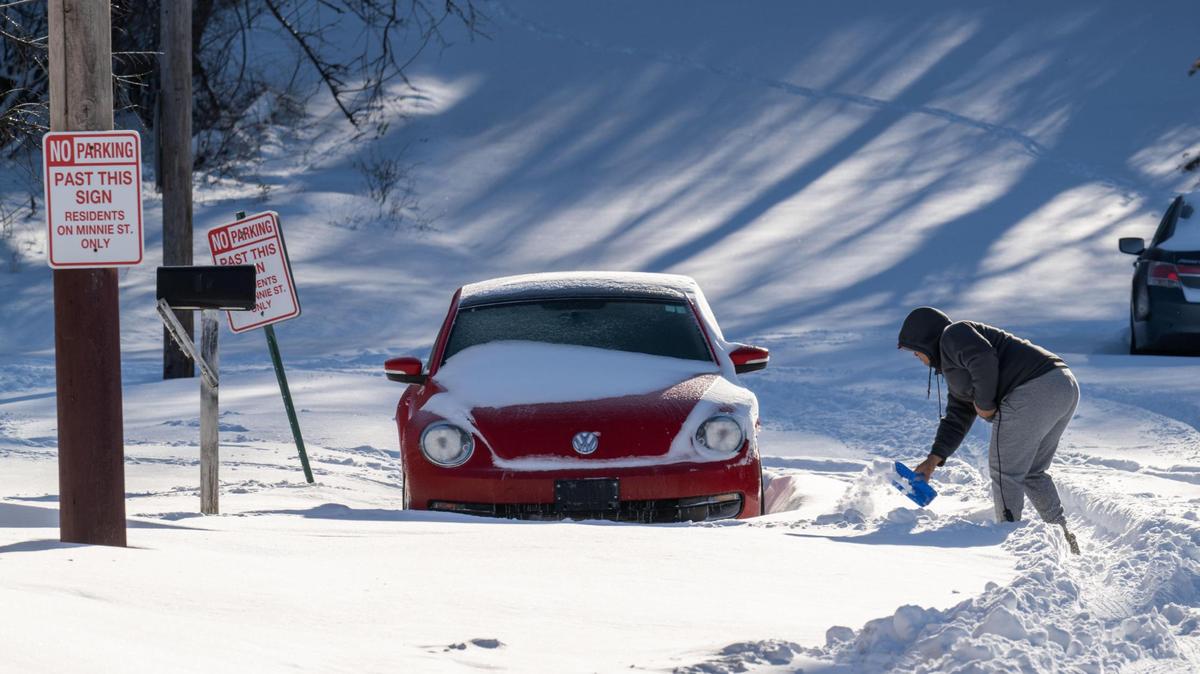 A man works to dig out his car from the snow along Southwest Boulevard in Kansas City on Monday. The Kansas City metro area received record snowfall on Sunday.