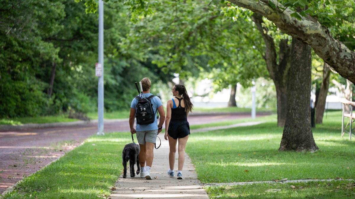 People walk along a path in Roanoke Park in Kansas City in July.