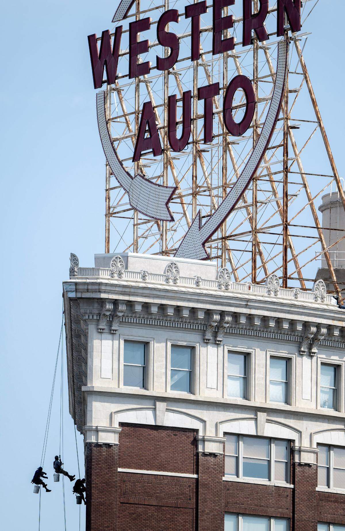 Window washers rappel down the side of the Western Auto Building on Wednesday, June 21, 2023.