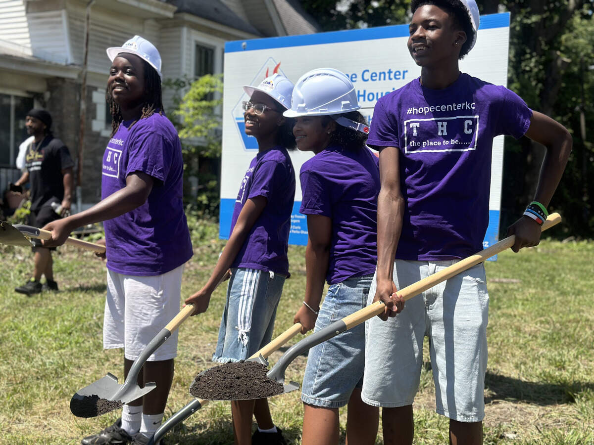 Four students with The Hope Center KC pose with shovels of dirt on July 13 at the groundbreaking ceremony