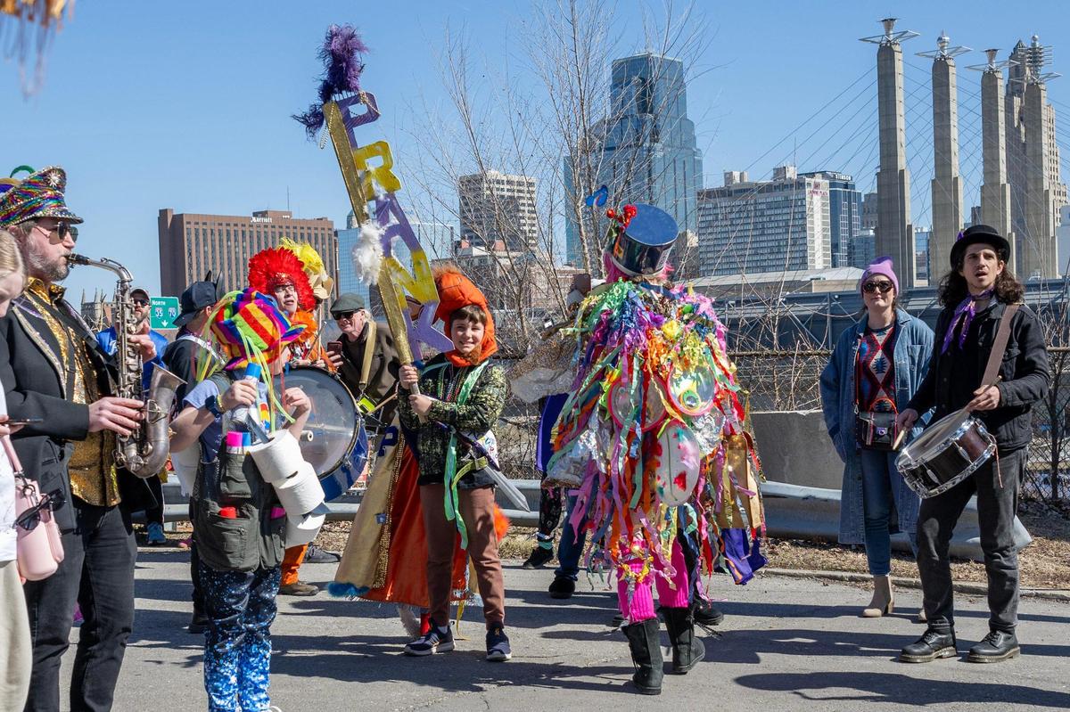 Bennett Sutherlin, child crowned as the 2025 Mardi Gras king, holds a prank staff, center, as parade participants walk along Jefferson Street during the annual Krewe de Prank parade Sunday, March 2, 2025, in Kansas City.