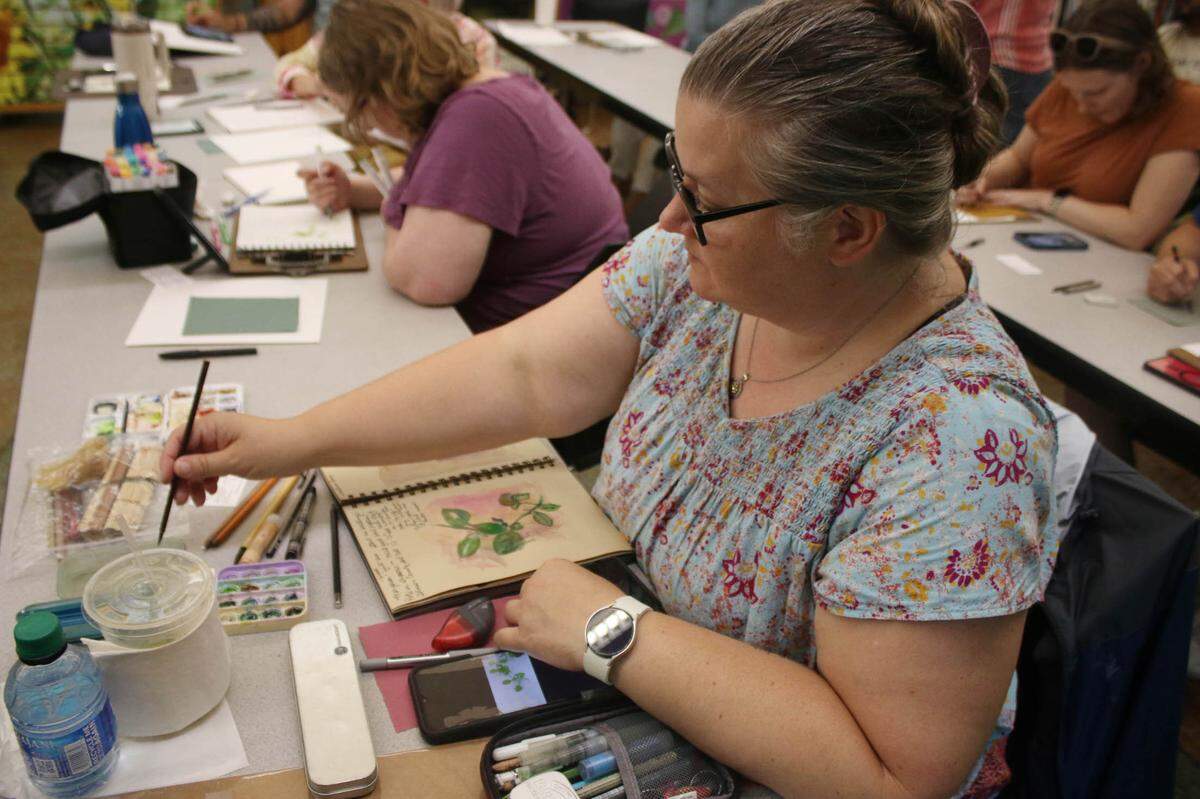 Oak Grove resident Brooke Wangwe adds some color to her picture of marjoram during the herb drawing class at the Overland Park Arboretum.