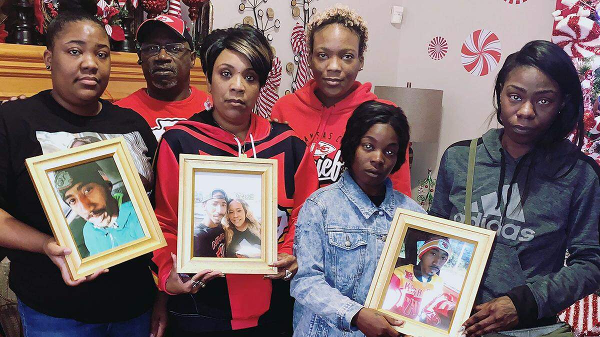 Members of Cameron Lamb’s family hold photos of the man fatally shot by a plainclothes Kansas City police detective.