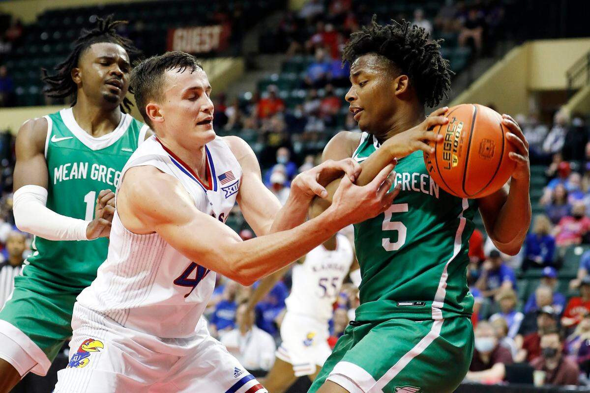 Kansas forward Mitch Lightfoot (left) and North Texas guard Tylor Perry (right) fight for the ball during the second half Thursday, Nov. 25, 2021, in Kissimmee, Florida.