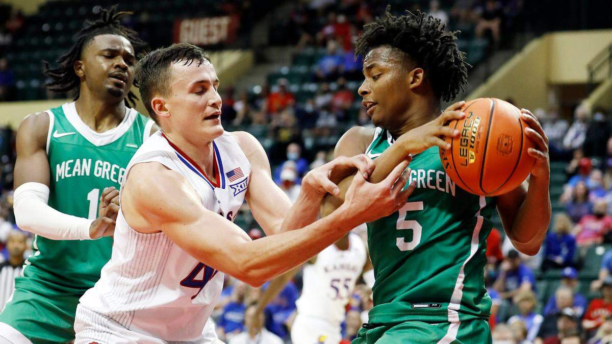 Kansas forward Mitch Lightfoot (left) and North Texas guard Tylor Perry (right) fight for the ball during the second half Thursday, Nov. 25, 2021, in Kissimmee, Florida.
