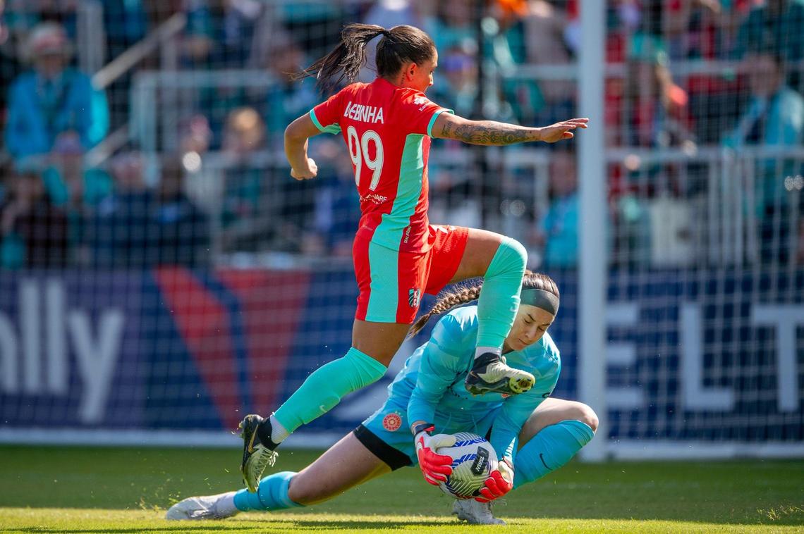 Kansas City Current midfielder Debinha (99) leaps over Portland Thorns FC goalkeeper Shelby Hogan (18) in an attempt to score a goal during the first half of an NWSL match against the Portland Thorns FC at CPKC Stadium on Saturday, March 16, 2024, in Kansas City.