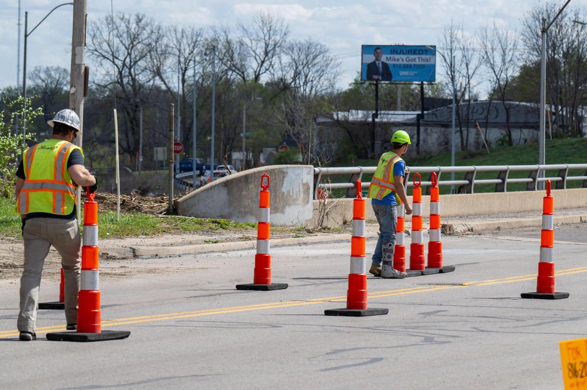 Construction workers move cones on a bridge in Kansas City that will be worked on as part of new I-70 updates on Thursday, April 10, 2025.