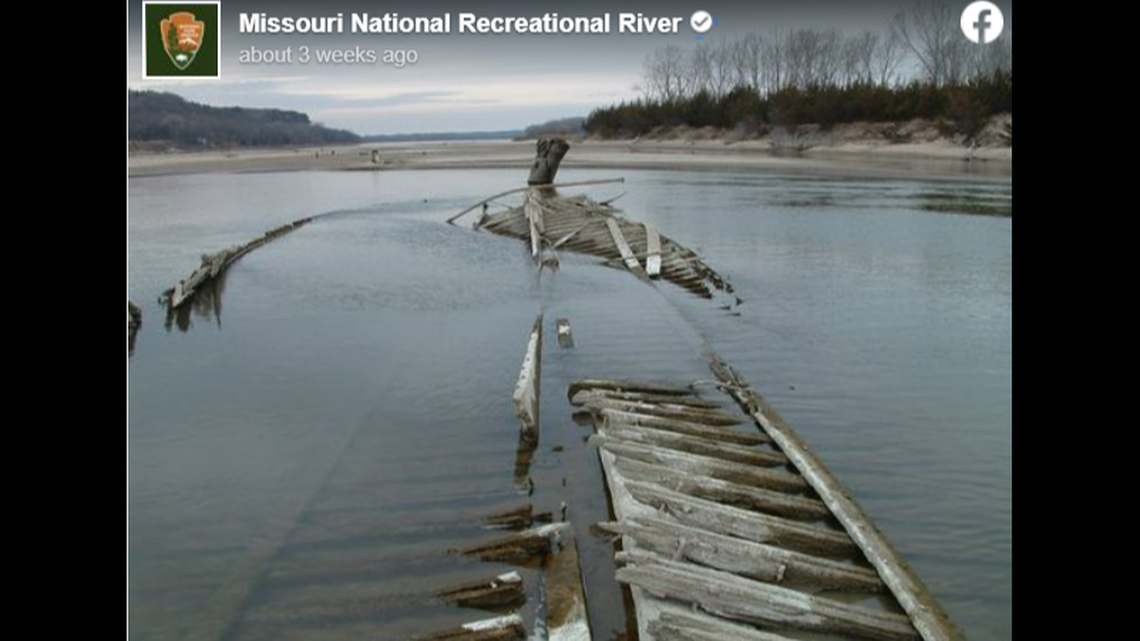 The spine of the wreckage breaches the river’s surface, drawing visitor attention.
