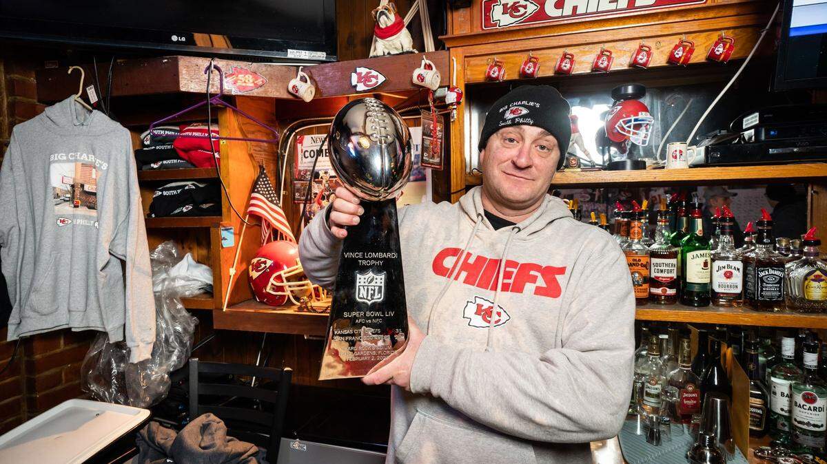 Michael Puggi, who grew up around the corner from Big Charlie’s Saloon, posed recently with a copy of the Lombardi Trophy that was gifted to the bar.