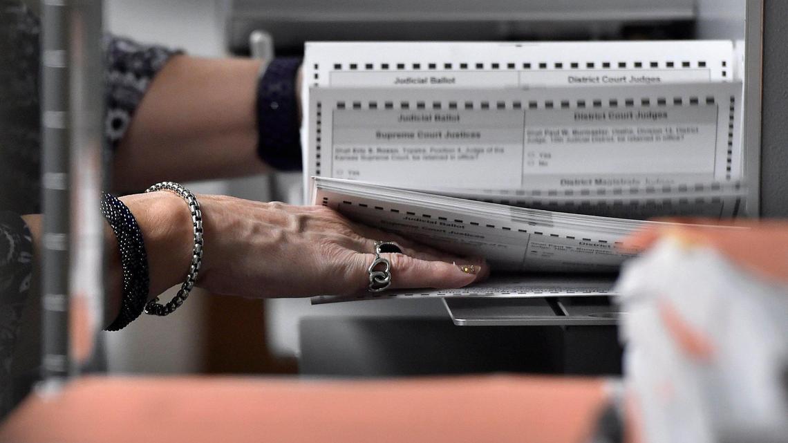 An election worker prepares mail-in ballots for scanning in October 2020 at the Johnson County Election Office in Olathe.