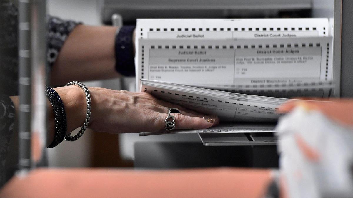 An election worker prepares mail-in ballots for scanning for the 2020 election at the Johnson County Election Office in Olathe.