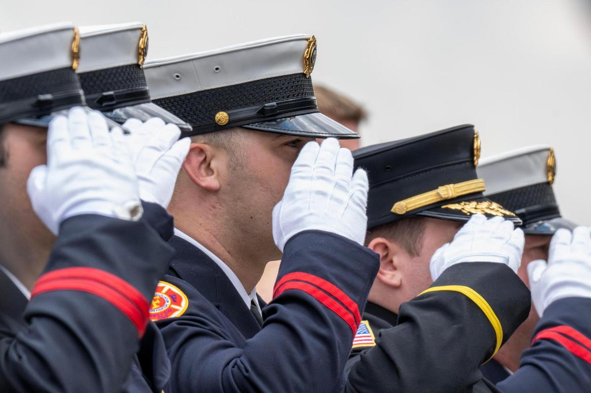 Firefighters salute as the casket of Kansas City Fire Department firefighter Graham Hoffman is rolled out of Pleasant Valley Baptist Church on Friday, May 2, 2025, in Liberty. Hoffman was stabbed inside an ambulance and later died as a result of his injuries. First responders and community members gathered to honor his life and service.