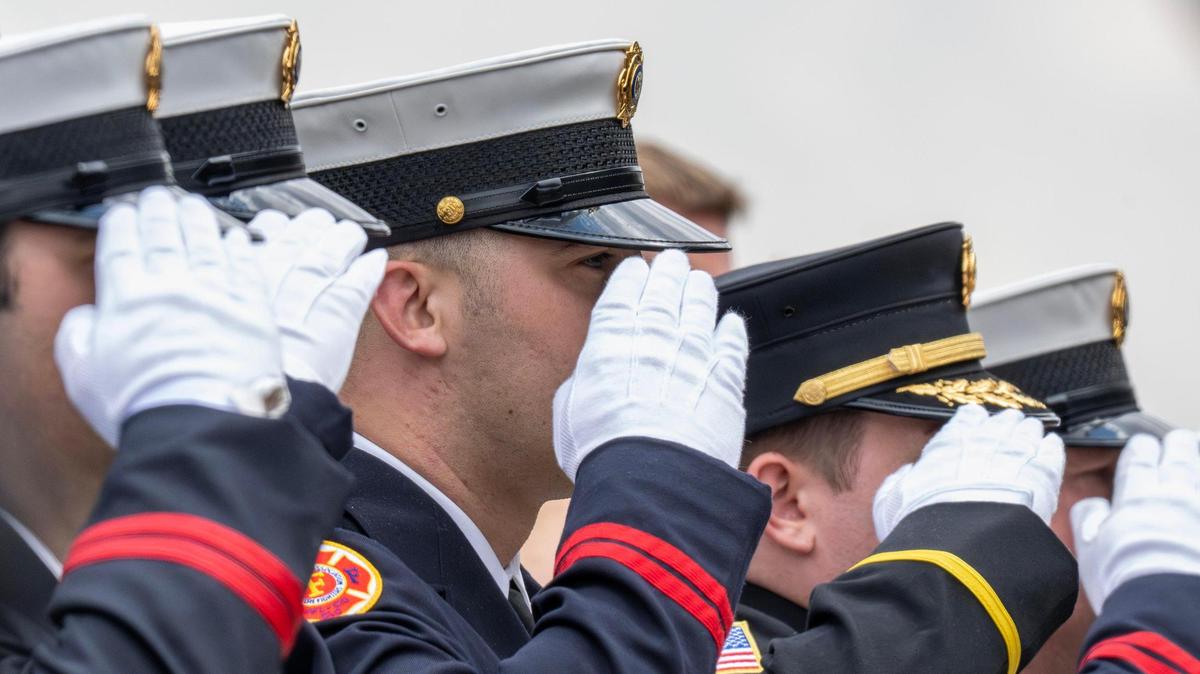 Firefighters salute as the casket of Kansas City Fire Department firefighter Graham Hoffman is rolled out of Pleasant Valley Baptist Church on Friday, May 2, 2025, in Liberty.