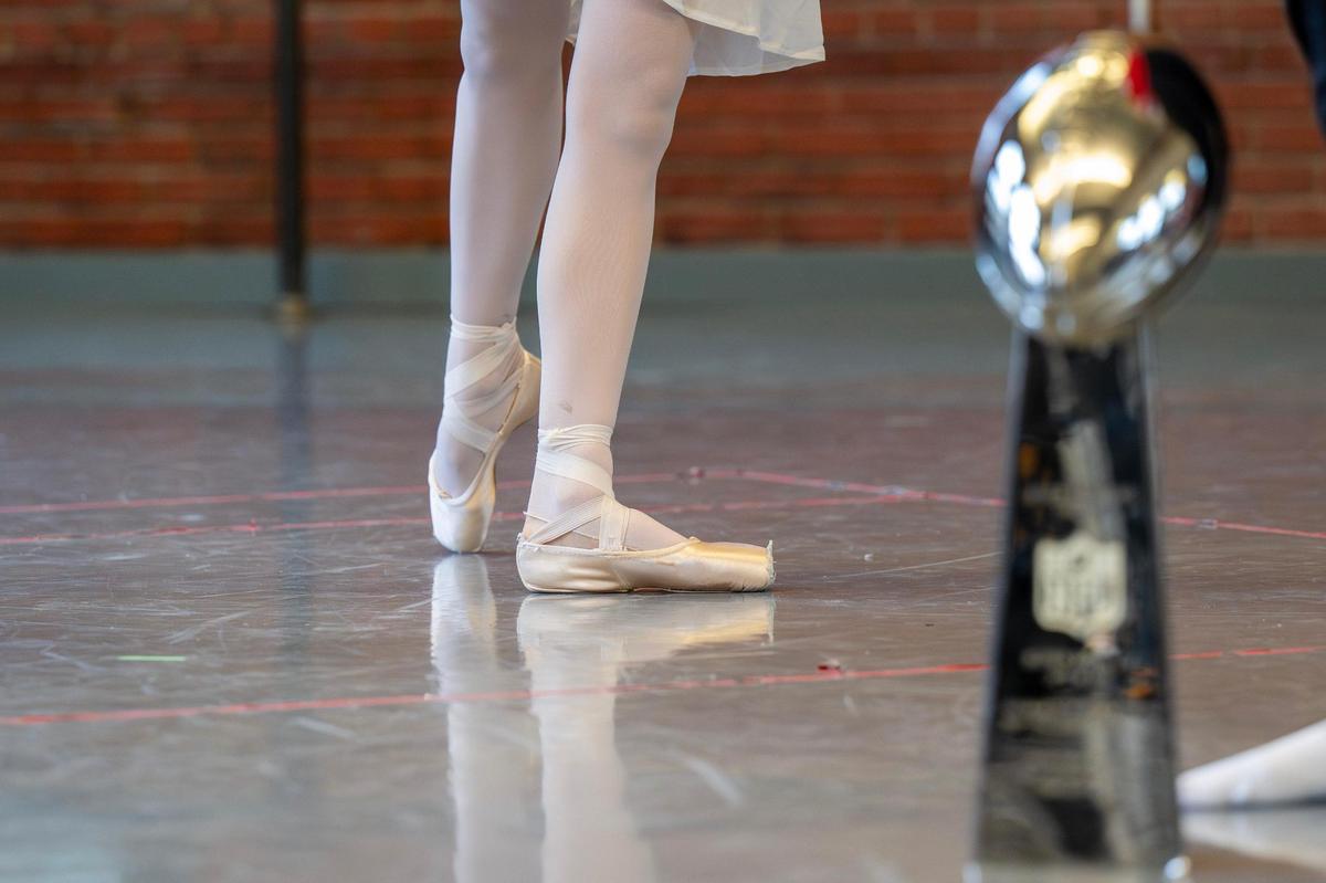 A ballerina dances alongside a replica of the Lombardi Trophy during the rehearsal.