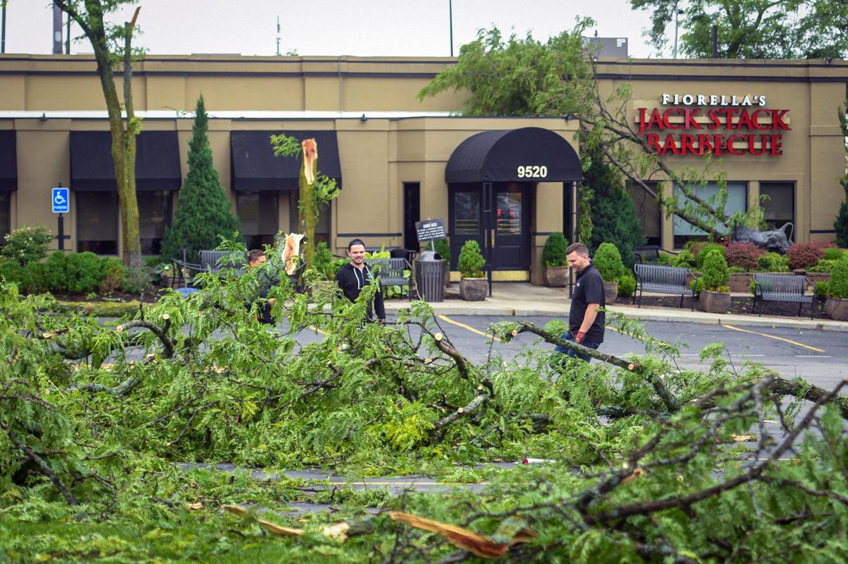 While awaiting crews from a tree company, Jake McCabe and Austin Carpenter assessed the tree damage at Fiorella’s Jack Stack Barbecue at 95th Street and Metcalf Avenue in Overland Park Wednesday, June 8, 2022. An early morning storm ripped across 95th street bringing down trees around the restaurant.