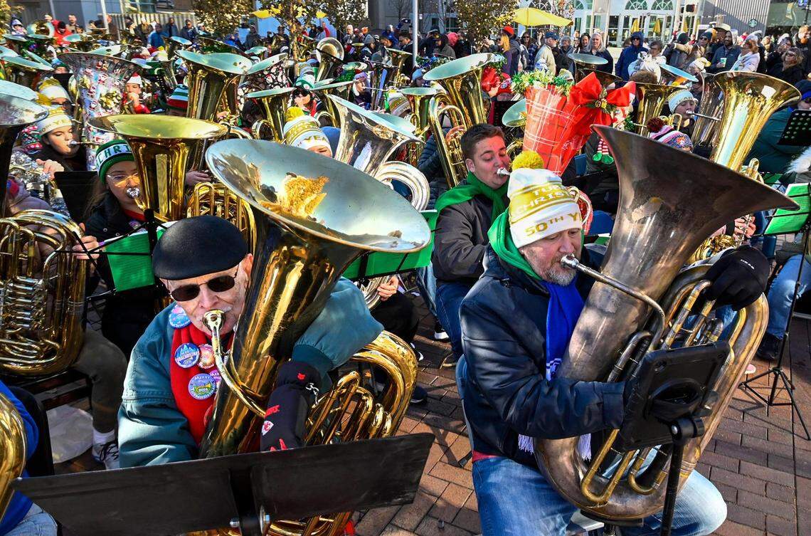Howard Bell, 91, left, of Kansas City, joined hundreds of local tuba and euphonium players who gathered outside Tuesday, Dec. 5, 2023, in the Crown Center Square for their annual TubaChristmas holiday concert. Bell has been playing the tuba for the past 79 years and said this was his 30th TubaChristmas.