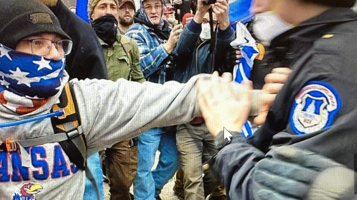 Prosecutors say Christopher Roe, left, shoves a U.S. Capitol Police officer during an altercation outside the Capitol on Jan. 6, 2021.